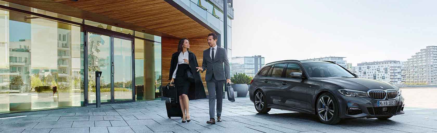 Une jeune femme et son partenaire partent en voyage d'affaires avec un abonnement BMW.