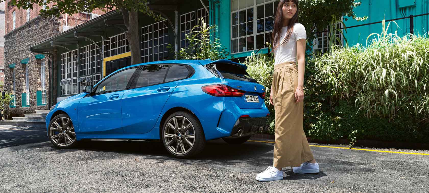 Jeune femme abonnée à une BMW bleue.